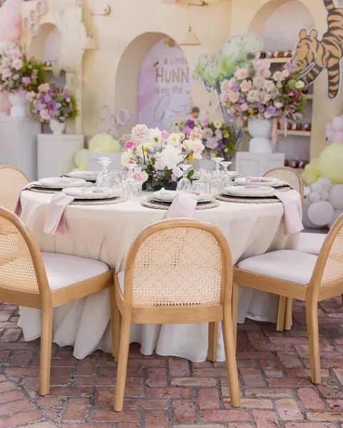 Baby shower table set with flowers, rattan chairs and balloons