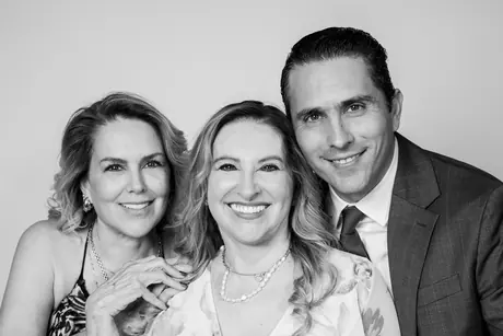 Black and white portrait of two women and a man smiling together