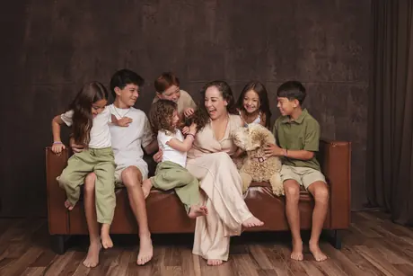 Large family laughing together on the studio sofa