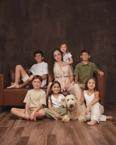 Large family with their dog on the studio sofa