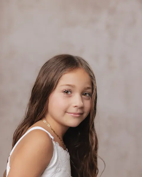Girl with long hair smiling over her shoulder