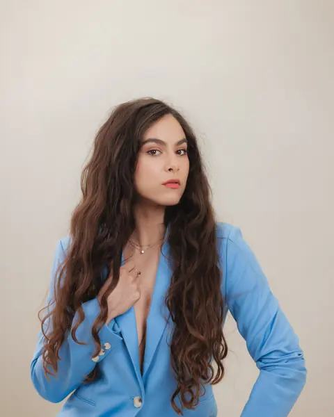 Portrait of a woman with long curly hair in a blue blazer