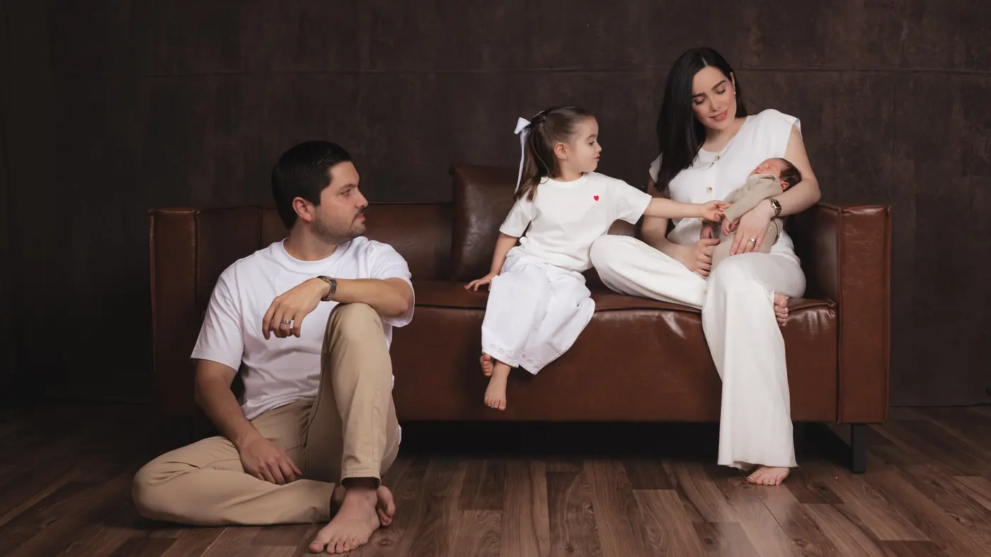 Family of four during a studio session, the father sitting on the floor