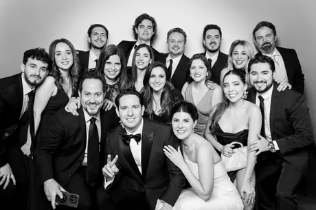 Large group of friends in formal wear crowding into one portrait