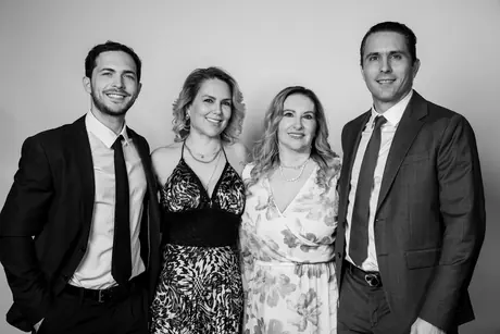 Two women and two men in formal wear standing side by side