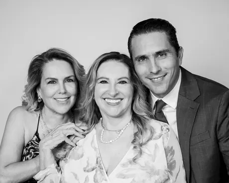 Two women and a man smiling cheek to cheek