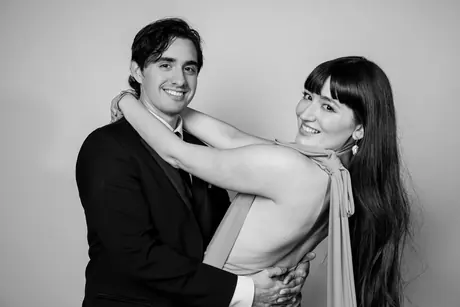 Woman in a backless dress embracing a man in a suit