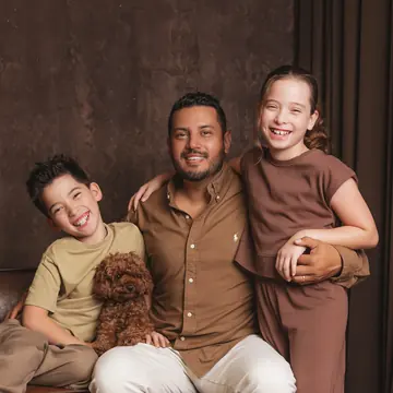 Roel Tobias with his son, his daughter and their puppy on the studio sofa