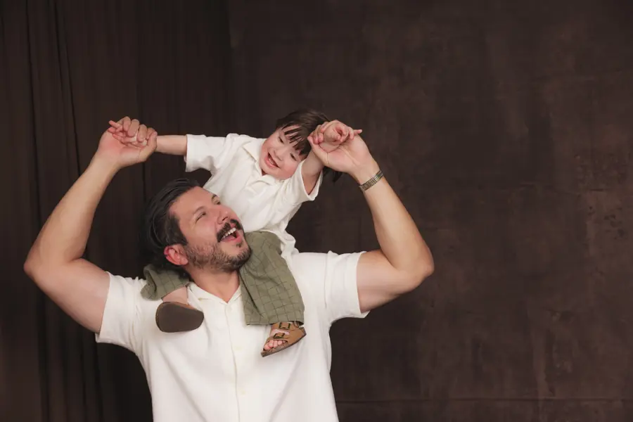 Father lifting his son onto his shoulders during a studio session